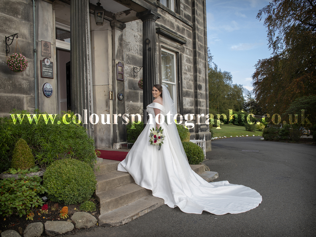 Garvock House Wedding Photographer Captures Bride at Doorway of The Fife Marriage Venue in Dunfermline Scotland KY12 7TU Photo by Colours Photographic Studio